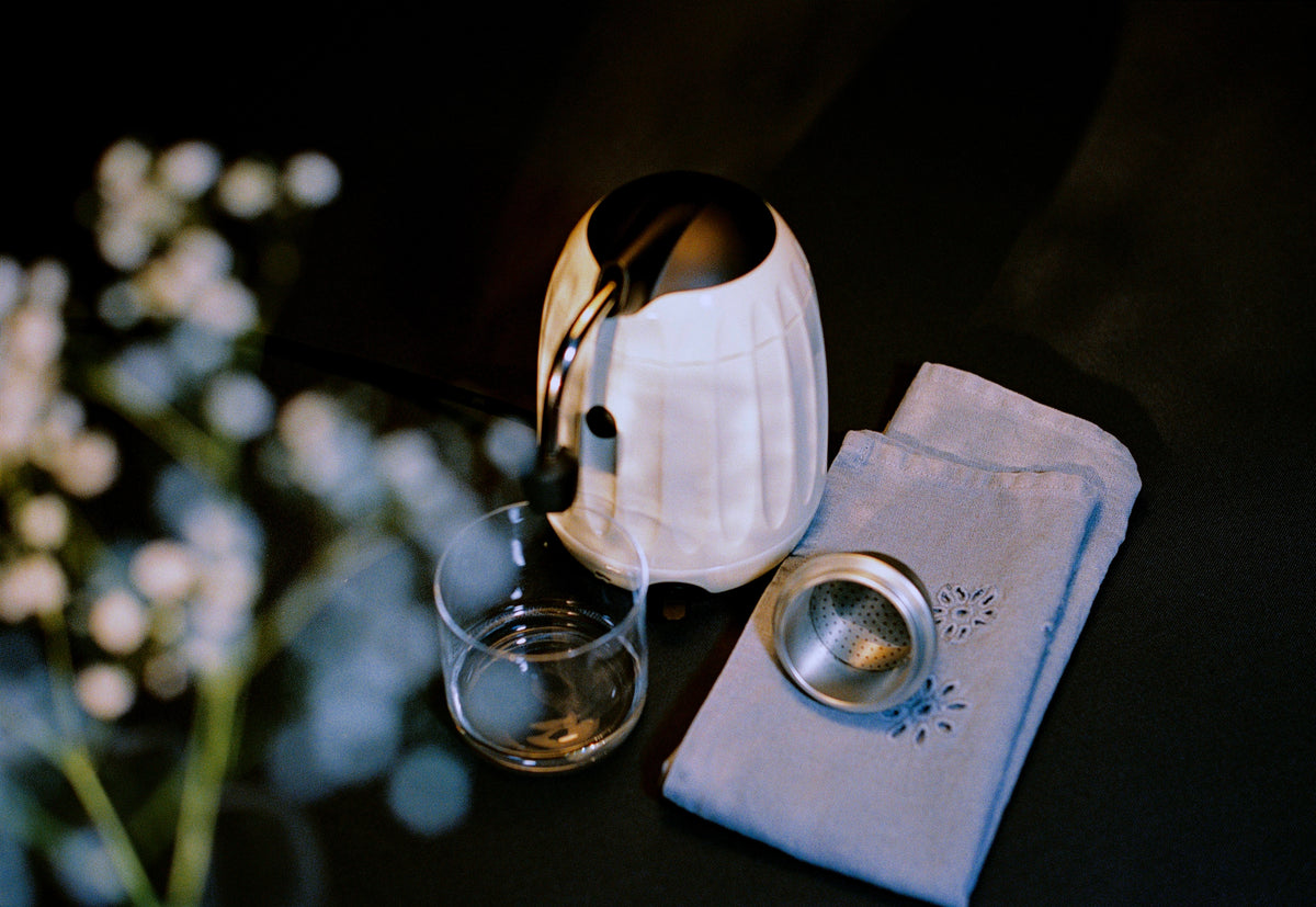Cream Mokapod on a dark table with flowers, ready to brew